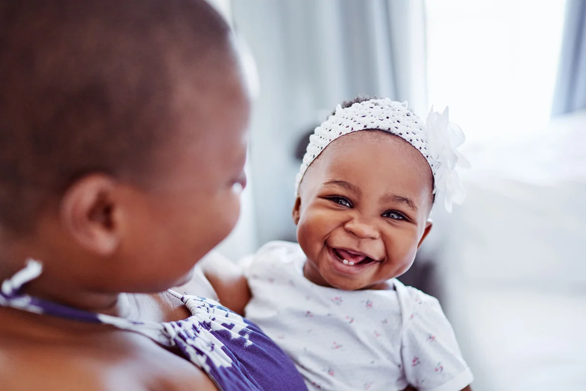 adorable baby girl bonding with her mother at home