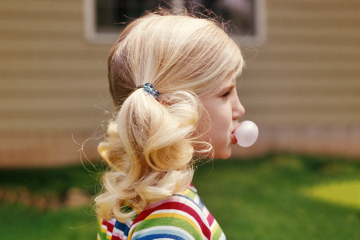 1970s PROFILE BLONDE GIRL BLOWING BUBBLE PINK BUBBLE GUM | Getty Editorial Use