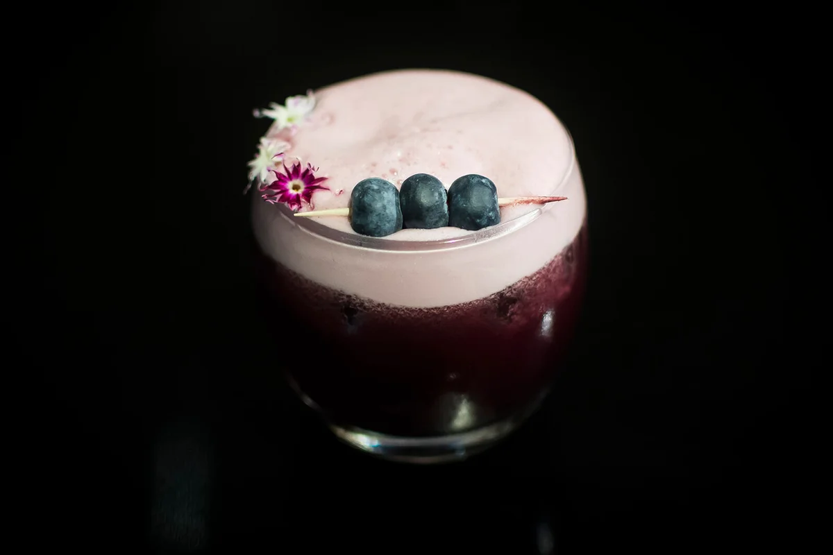 Pretty pink cocktail with blueberries and arctic berries