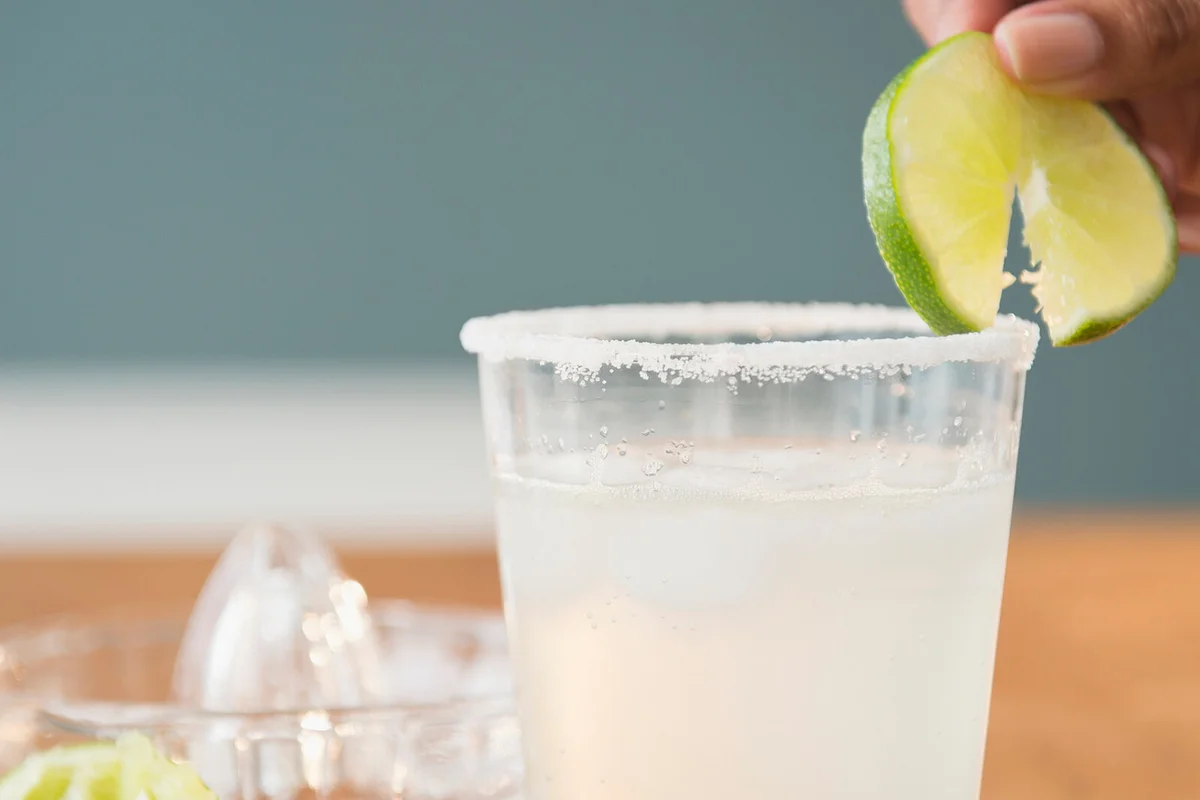Cape Verdean woman putting lime on cocktail
