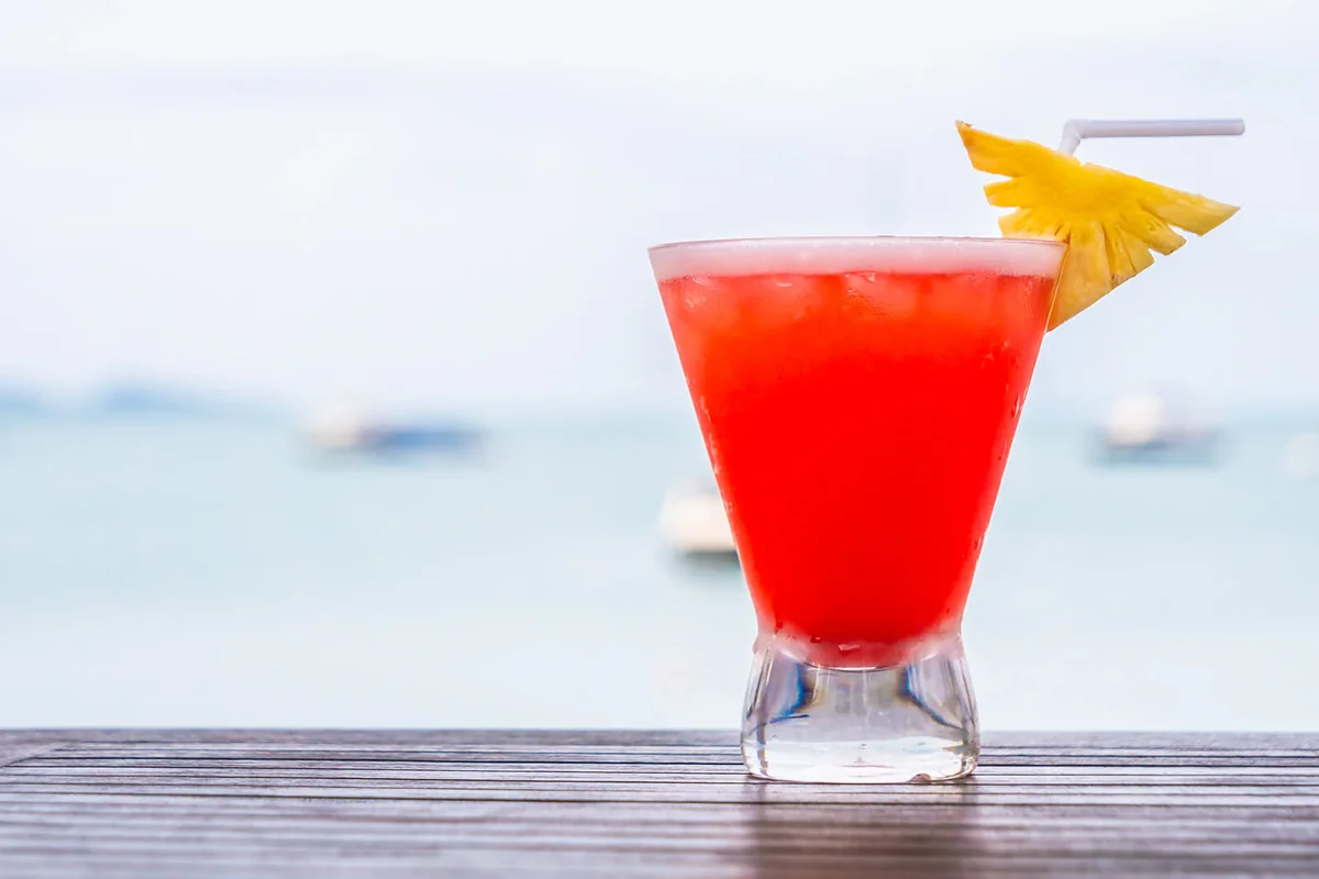 Red Drink In Glass On Table Against Sea