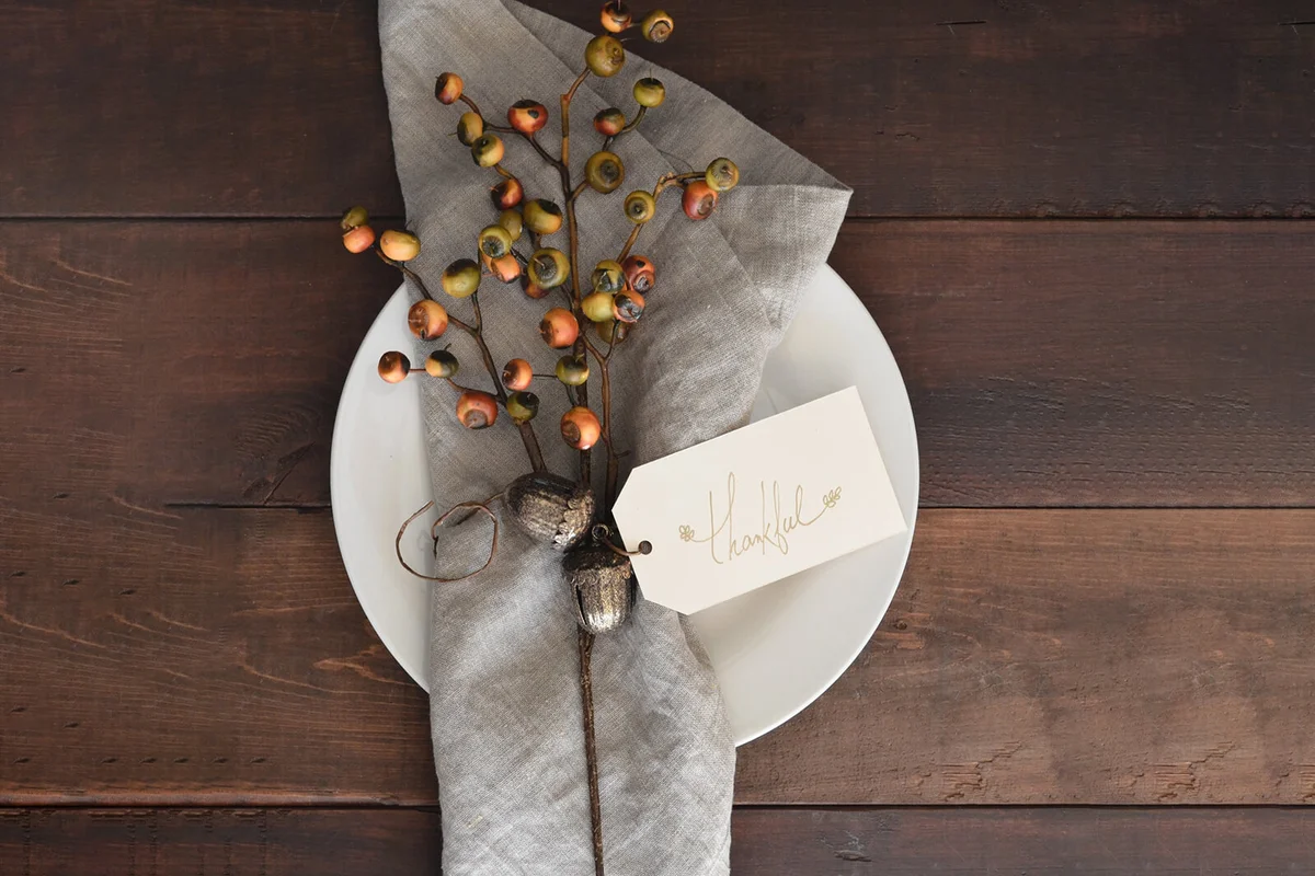 Directly above shot of text on paper with Thankful text by autumn decoration