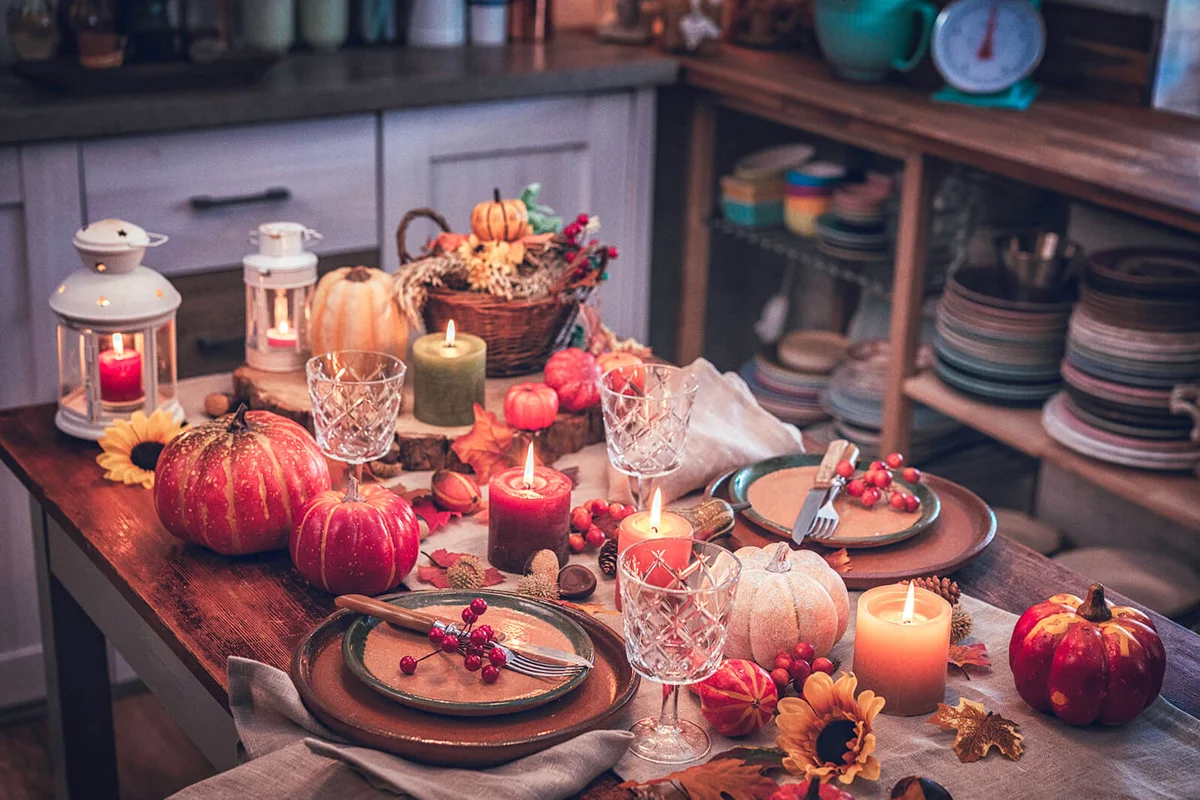 Decorated Table for Thanksgiving Dinner with Candles, Pumpkins, Leafs and Nuts