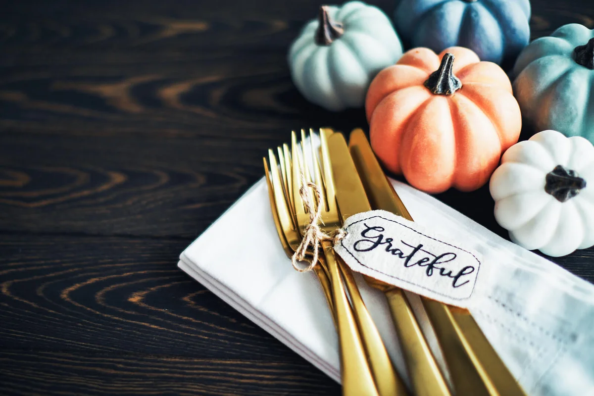 Thanksgiving Table Setting Background with Pumpkins and Gold Cutlery