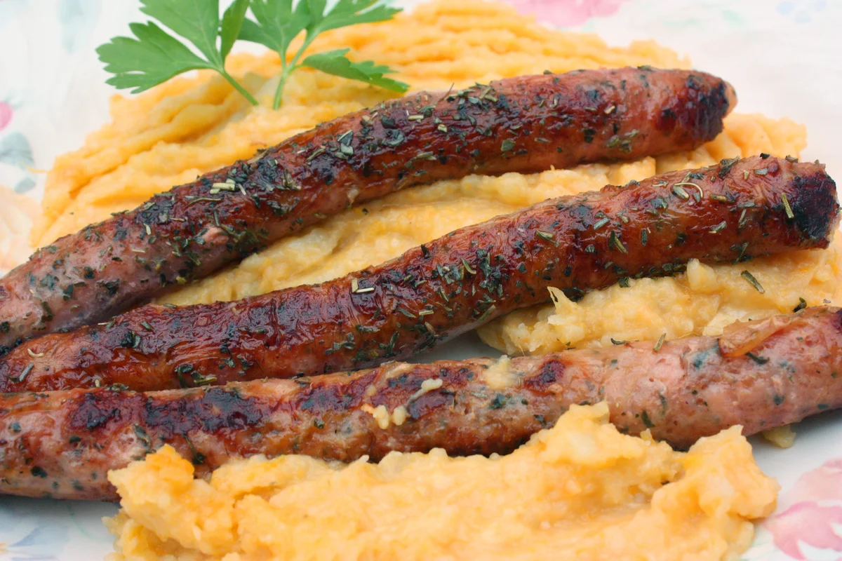 Pork sausages served with mashed potatoes and sweet potatoes
