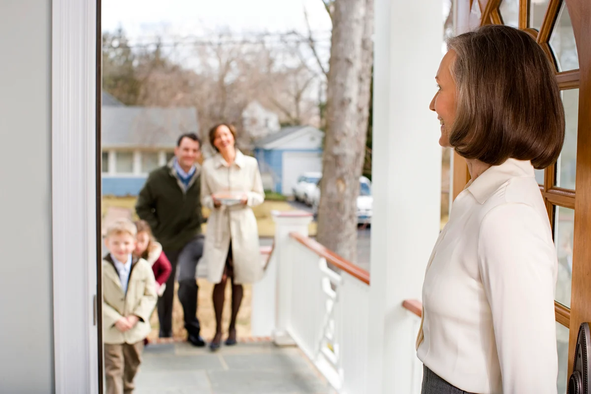 Woman welcoming guests to Thanksgiving