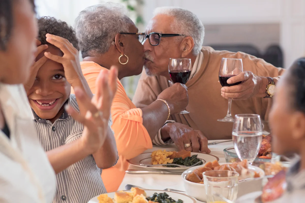 Family having fun and toasting with drinks at dining table