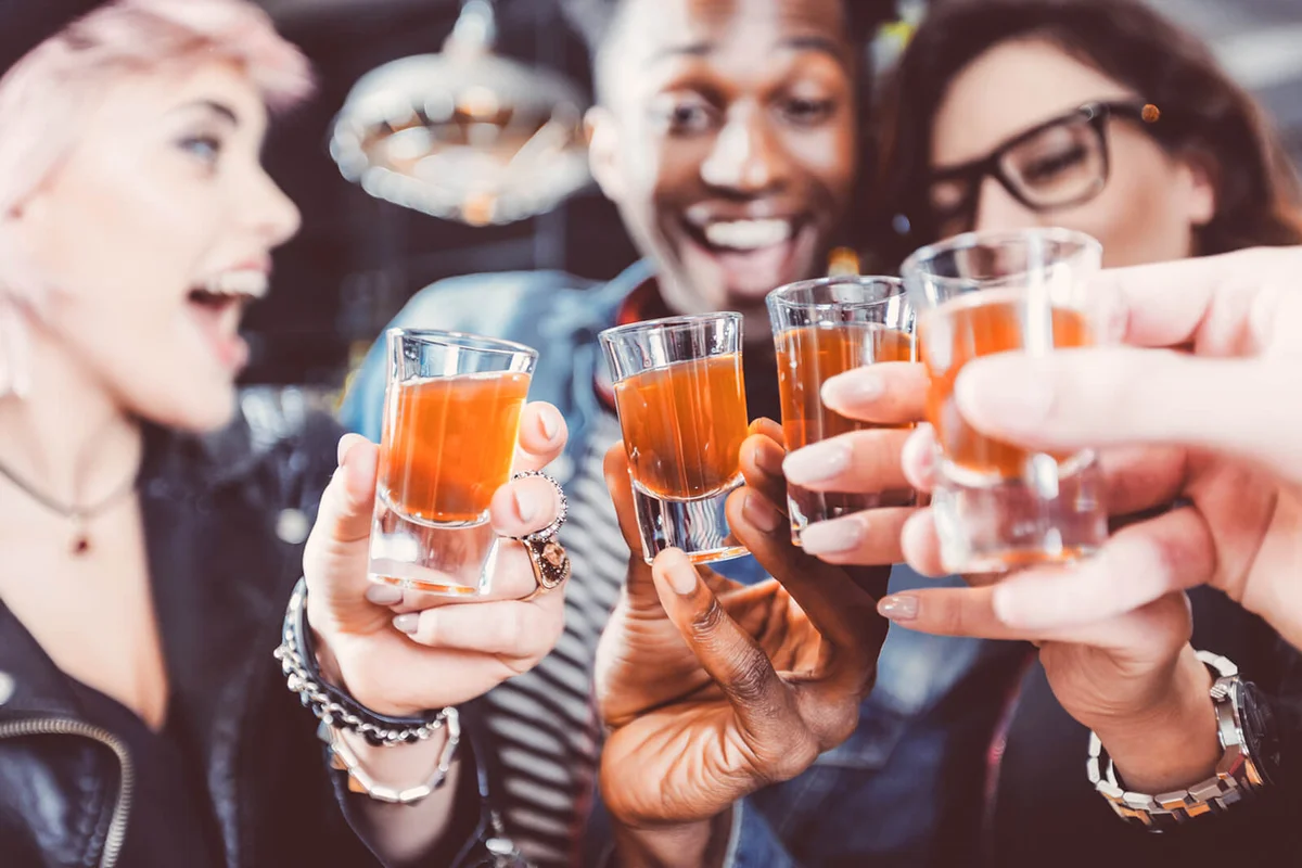 Happy friends drinking shots