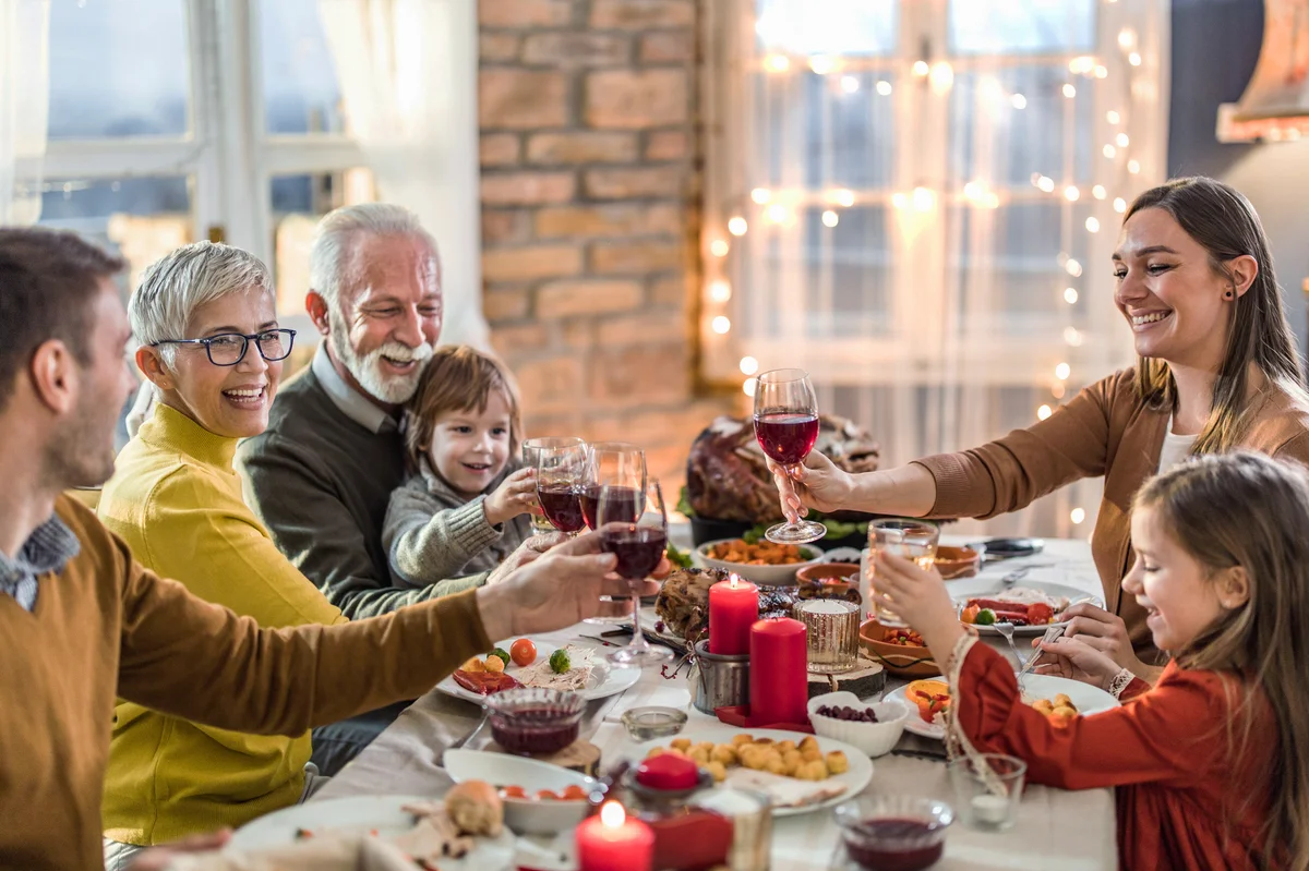 Happy extended family toasting during Thanksgiving lunch at home