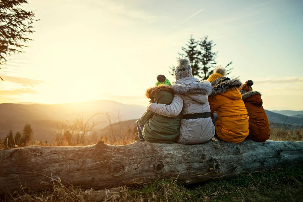 Mother and kids enjoying sunset in mountains