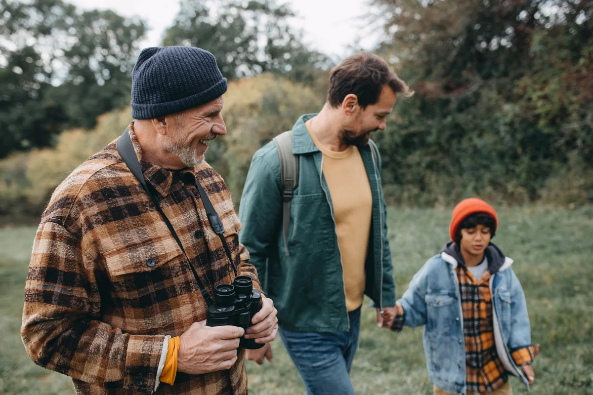 Boy with father and grandfather walking in the forest