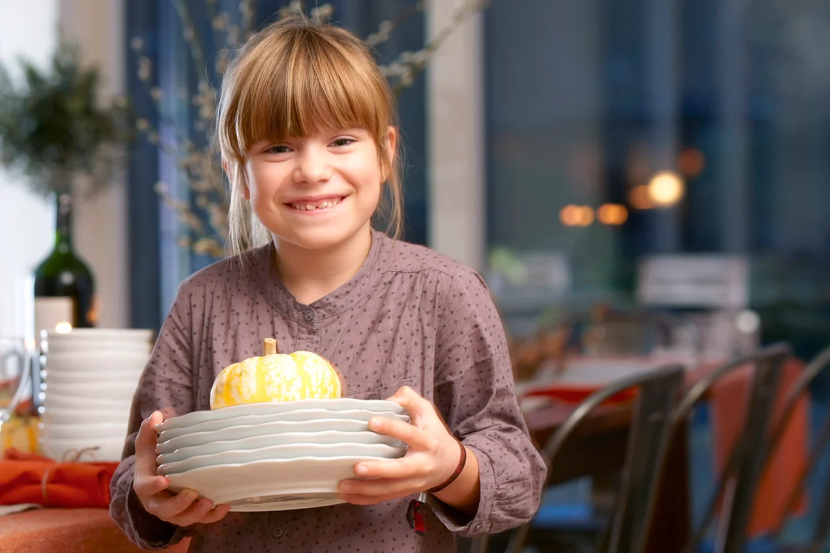 Girl with Thanksgiving gourd and plates