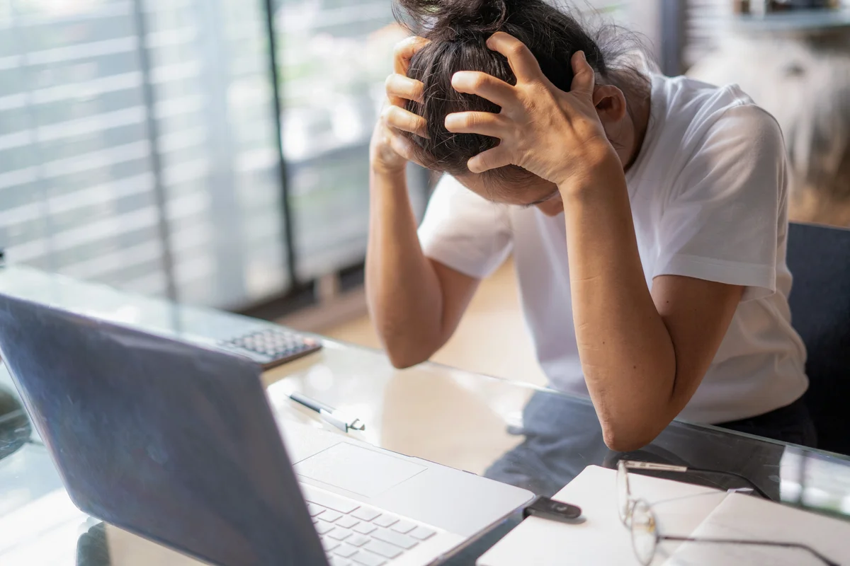 Tired young business woman stressing over computer