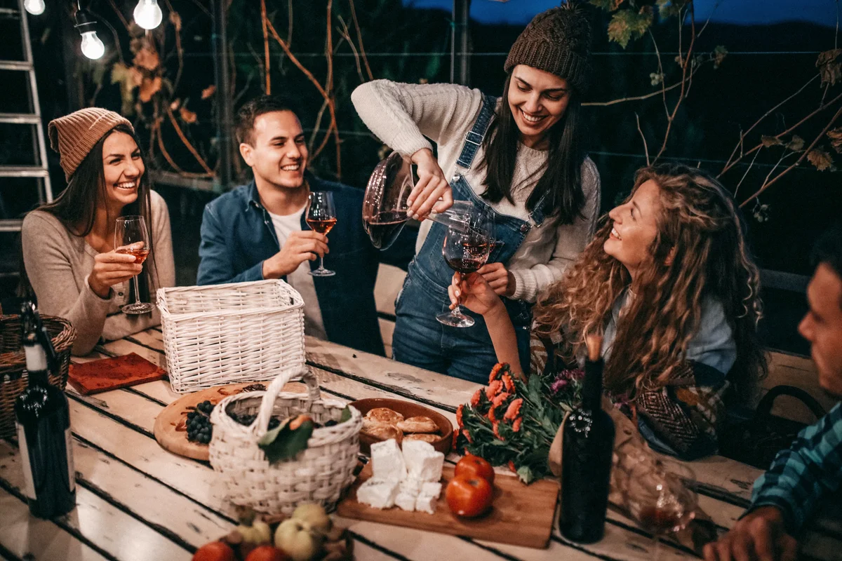 Young people enjoying wine in cabin