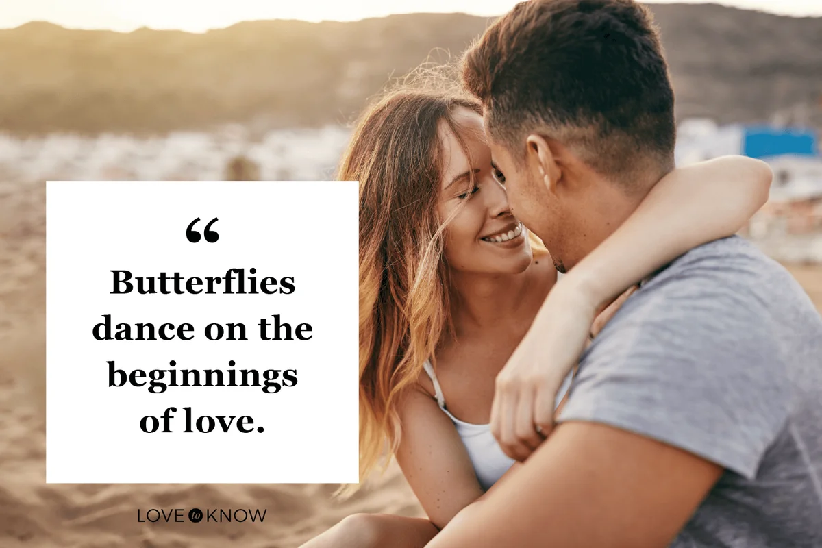Romantic young couple sitting together on a sandy beach