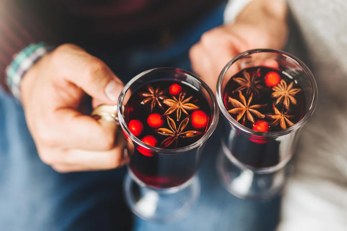 people clinking with glasses full of mulled wine withs spices