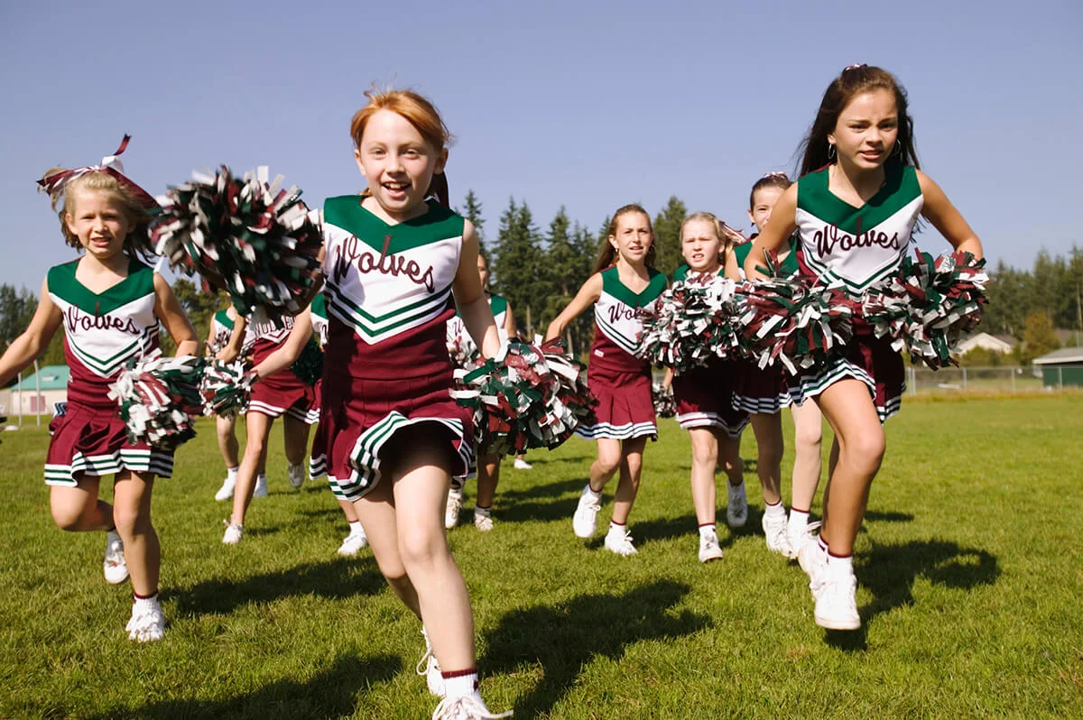 Cheerleaders running on an athletic field