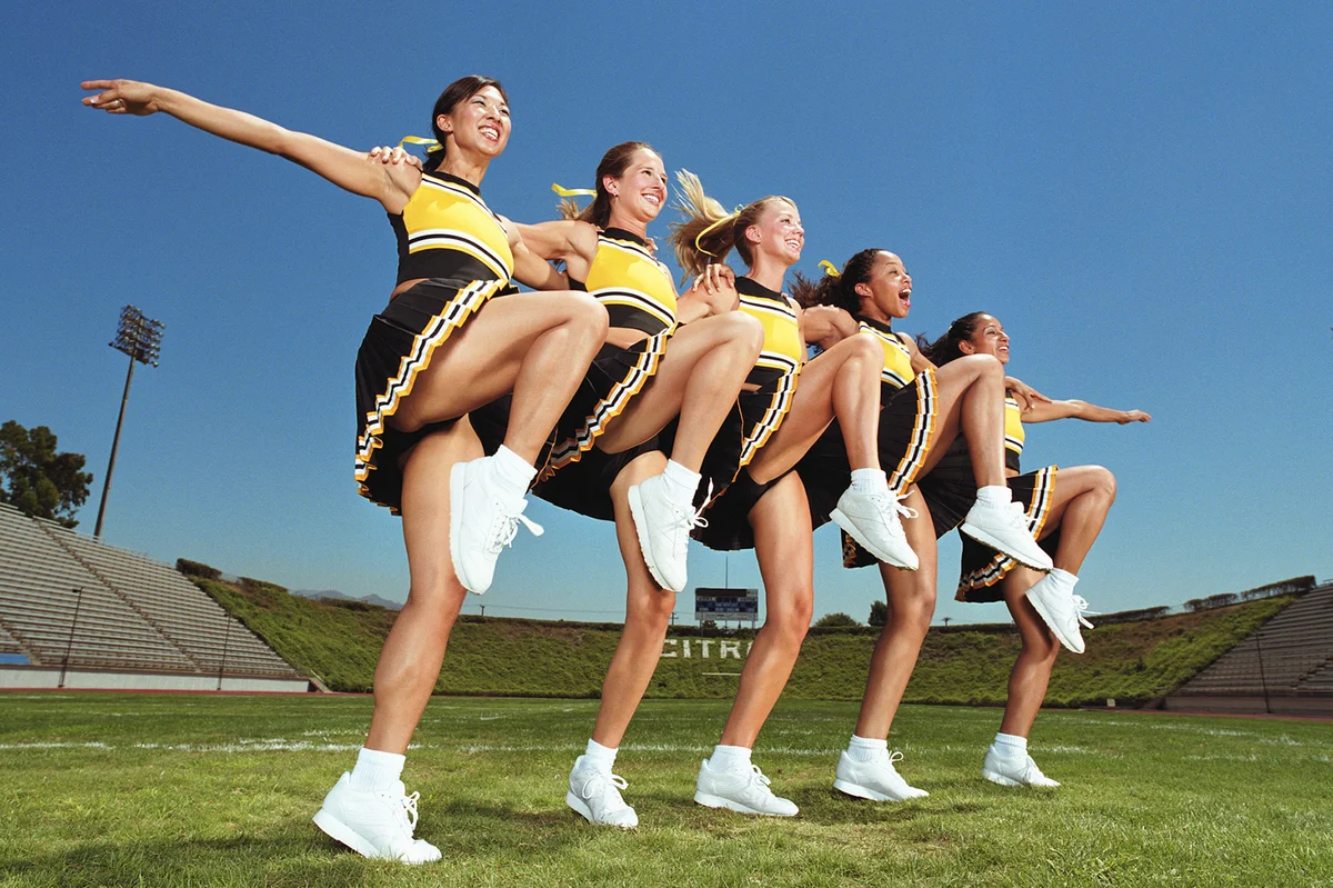 Cheerleaders dancing arm and arm in formation