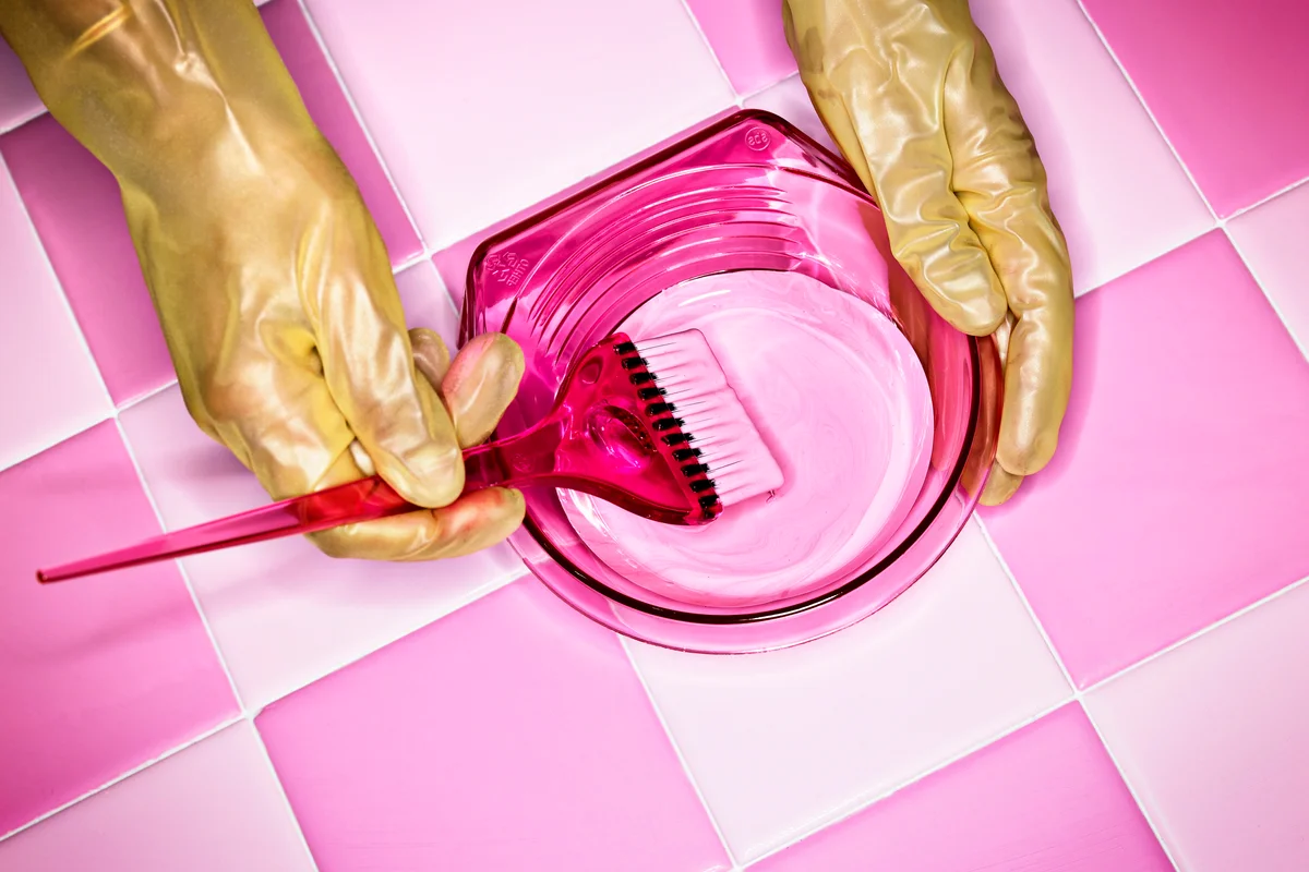 Hand with gloves preparing hair tint