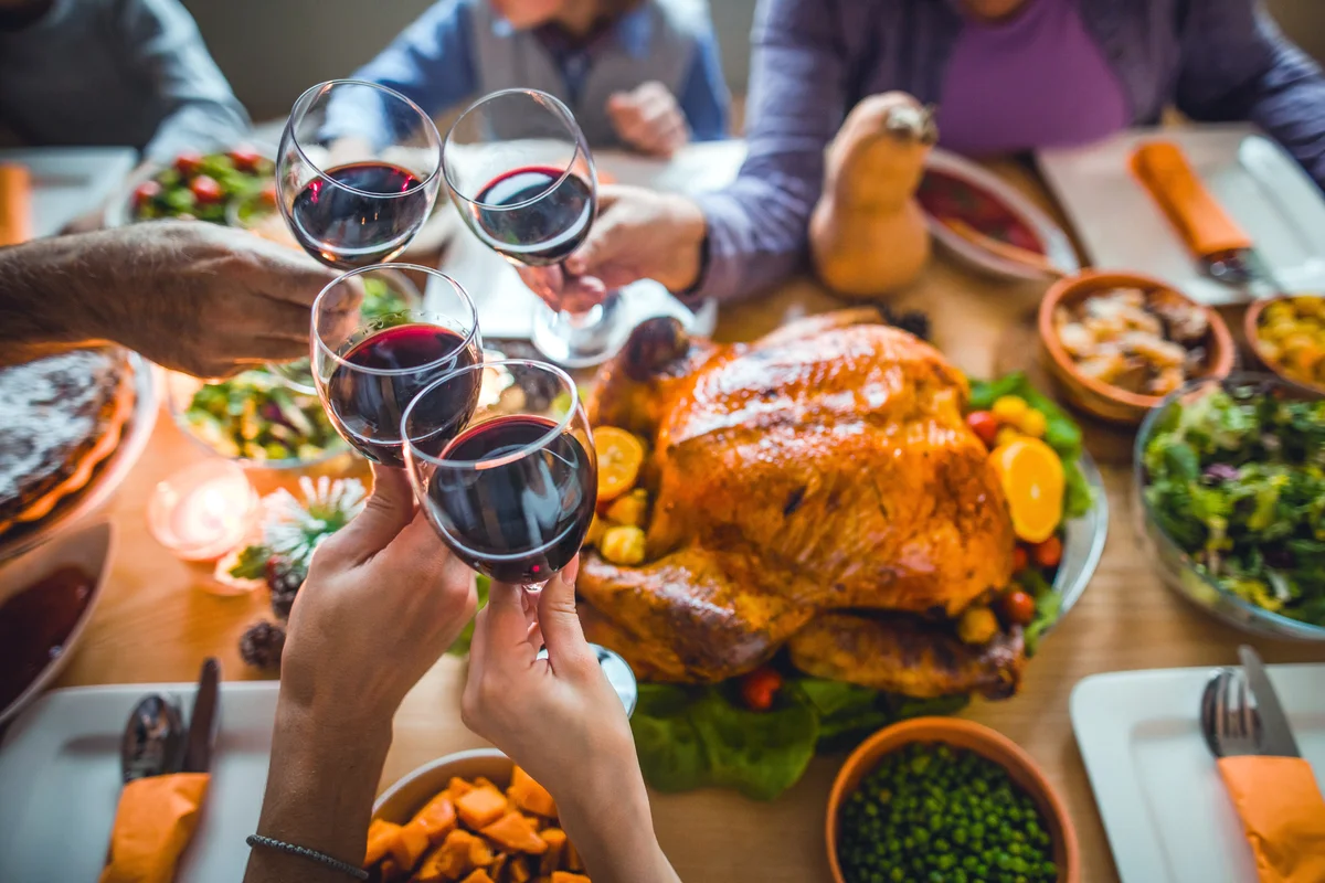 People toasting with wine during Thanksgiving dinner