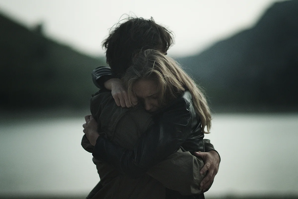 Couple hugging in mountains. Reconciling after crisis
