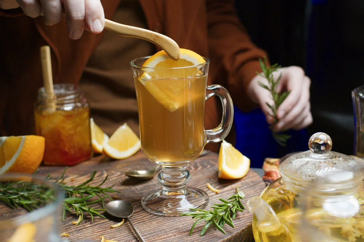 Woman preparing hot toddy with orange