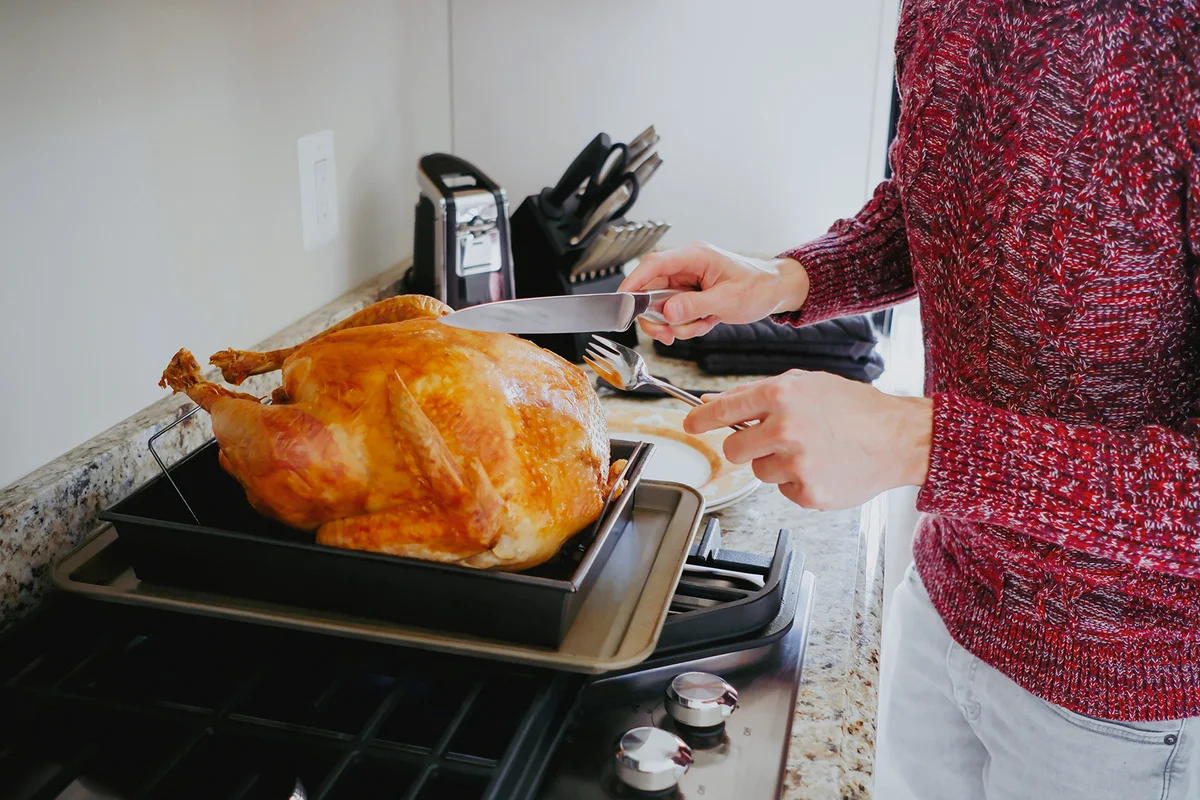 Woman Prepares to Carve Turkey for Holiday Meal