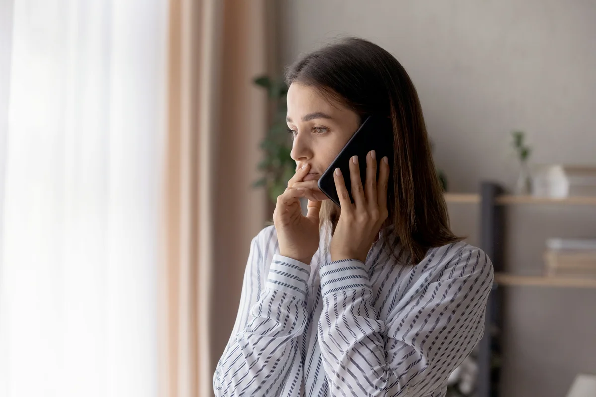Sad compassionate young woman support friend in phone talk
