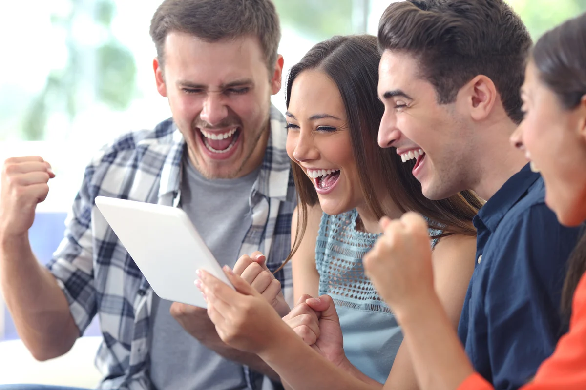 Excited group of friends playing would you rather game on tablet