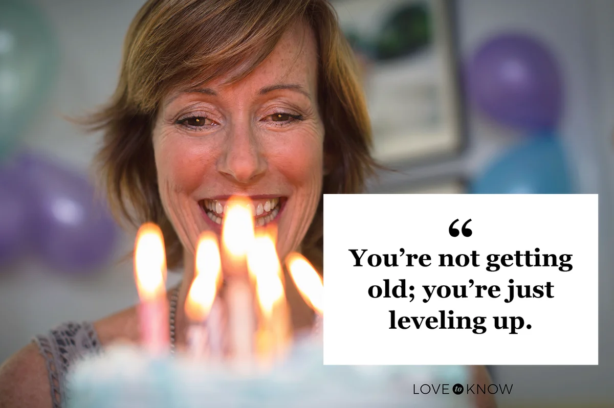 Mature woman holding birthday cake with candles