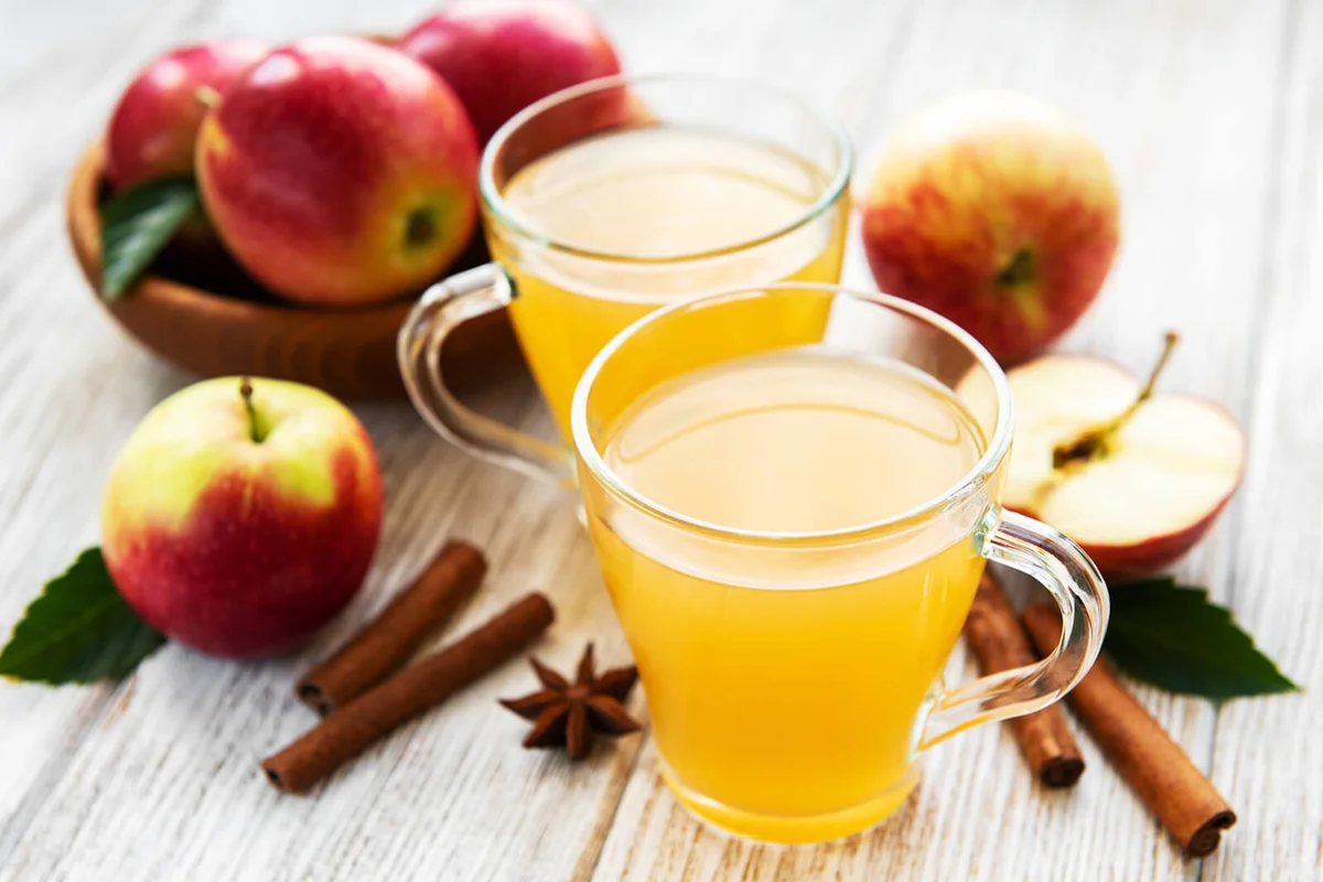 Apple cider with cinnamon sticks on a old wooden table