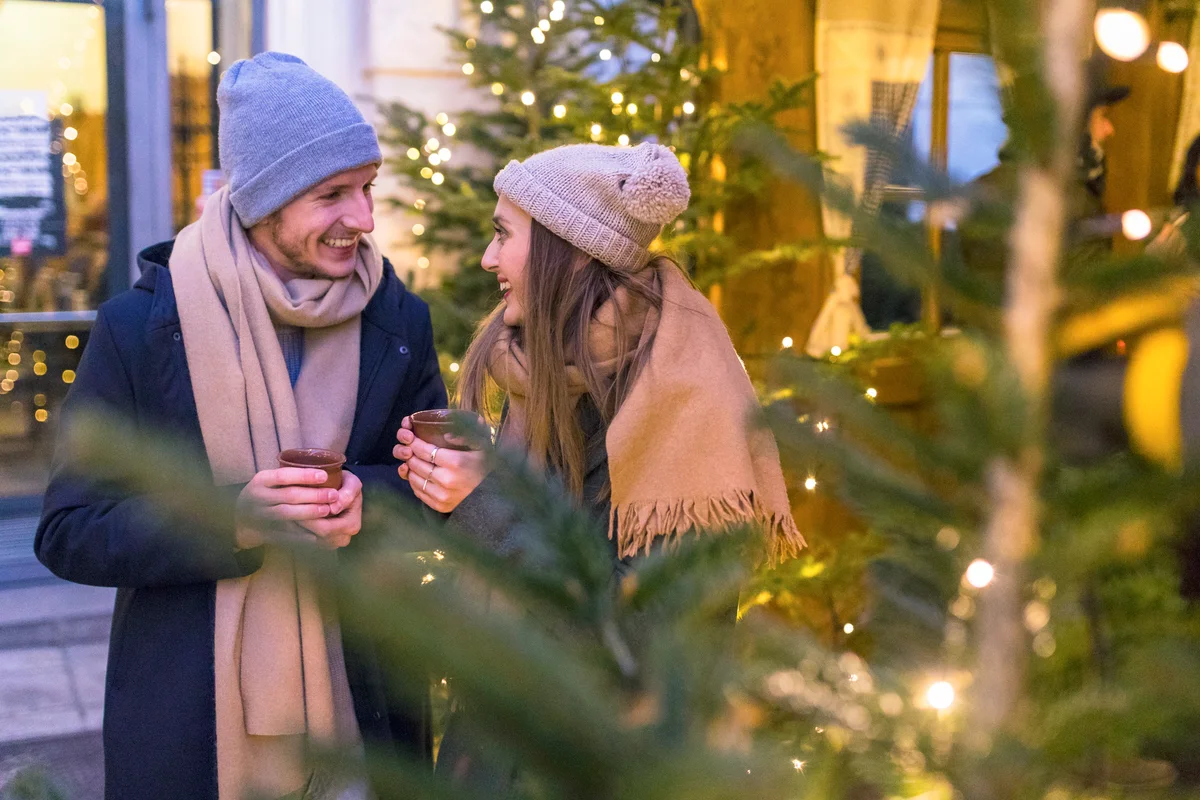 Happy young couple drinking gluhwein at Christmas market