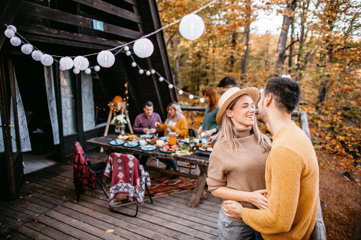 Young cute couple bonding at friendsgiving lunch at cabin
