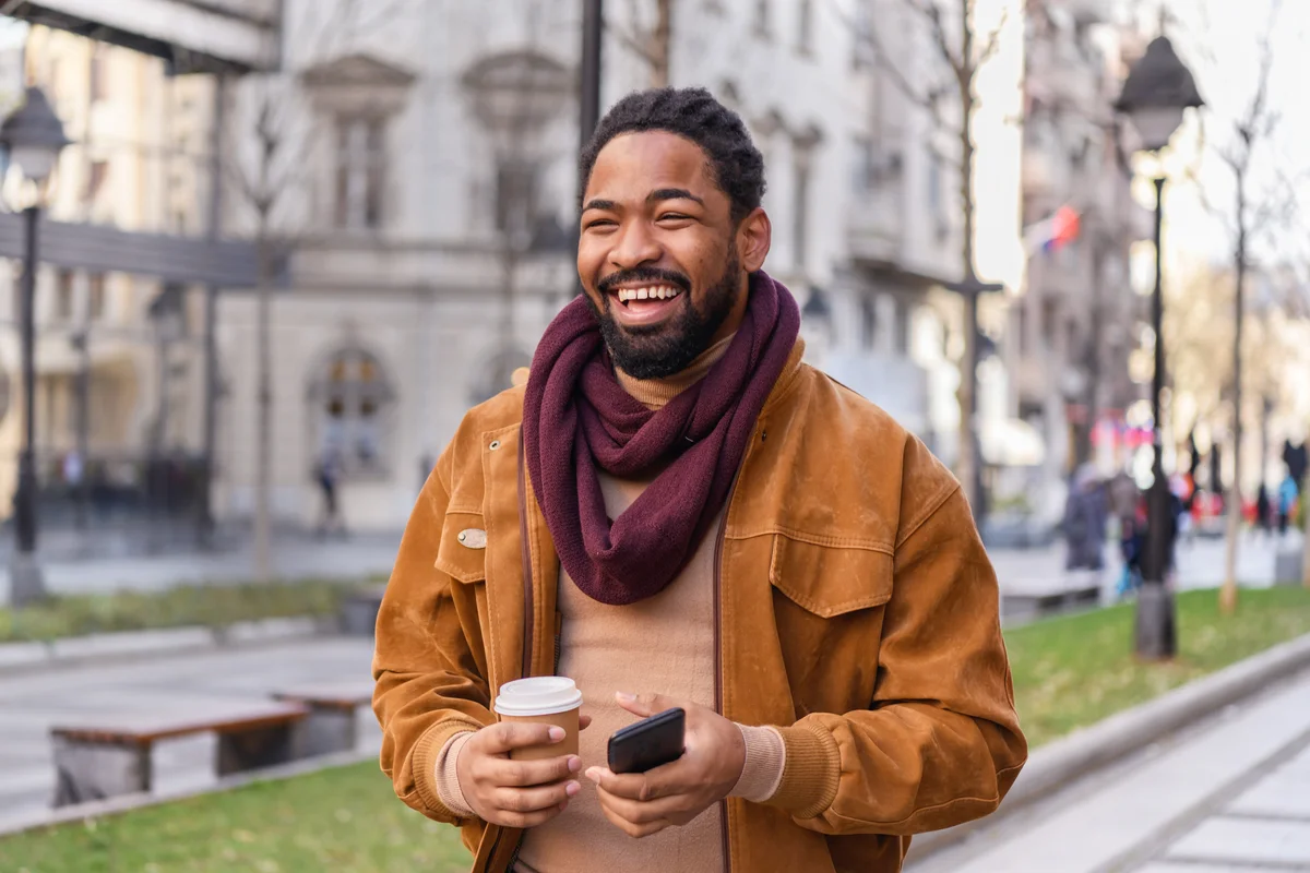 Portrait of a Handsome African Man with Coffee Walking in the City Streets