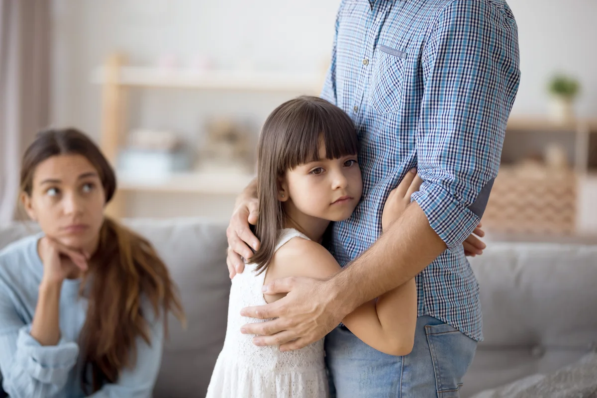 Preschooler daughter gives a sad hug to her father