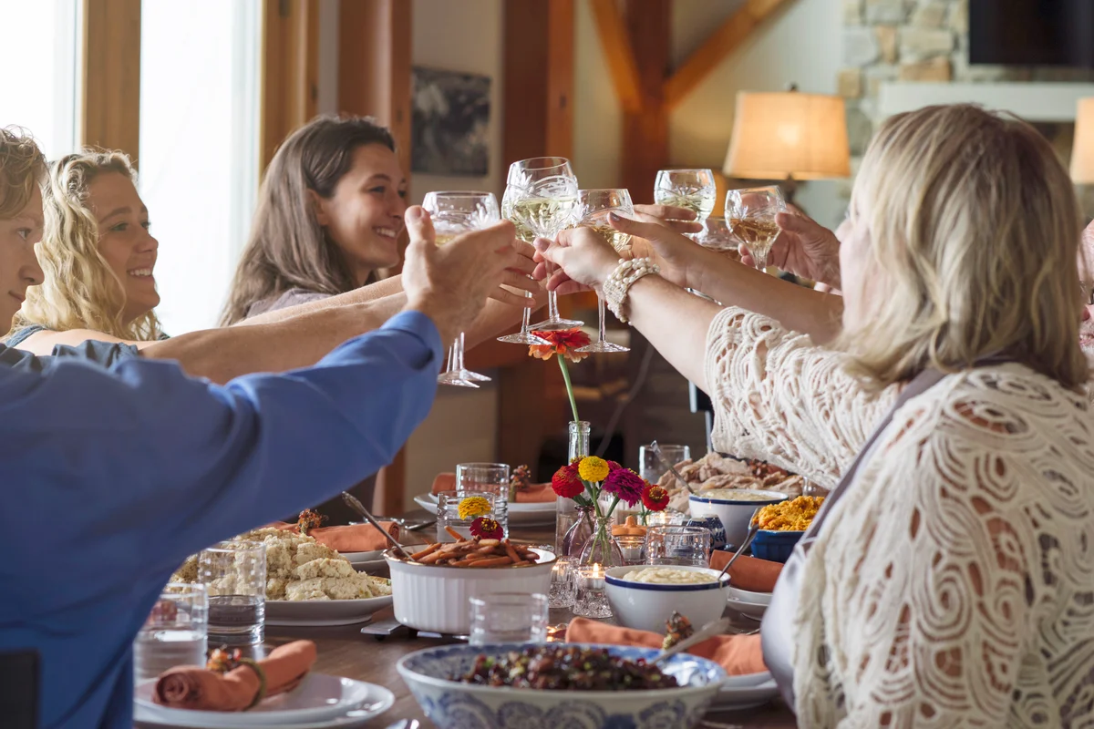Happy family making a toast while sitting at dining table during Thanksgiving