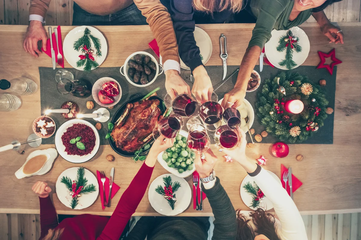 Overhead view on people clinking wine glasses at christmas table