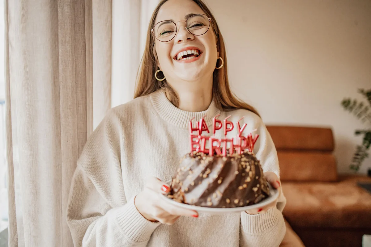 Portrait of a smiling young woman holding birthday cake