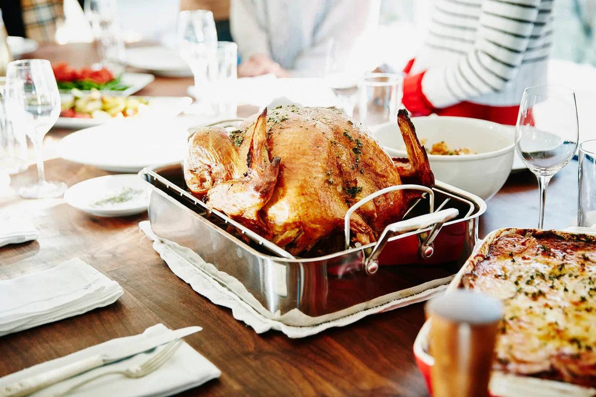 Turkey in roasting pan on table for holiday meal