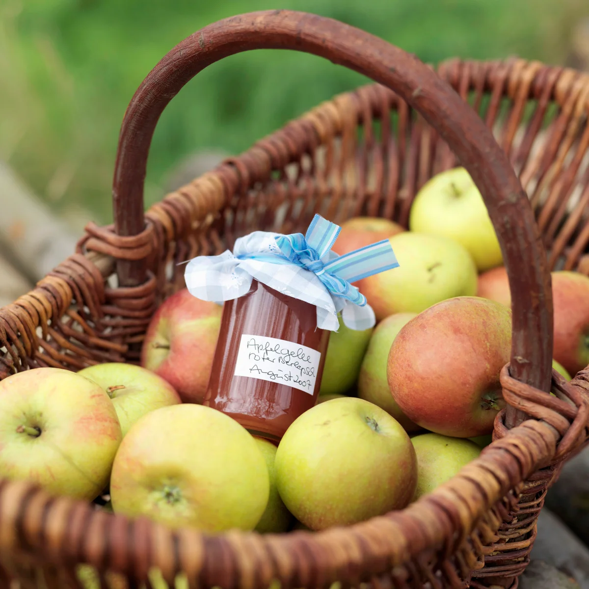 Apples in basket with jar of applesauce