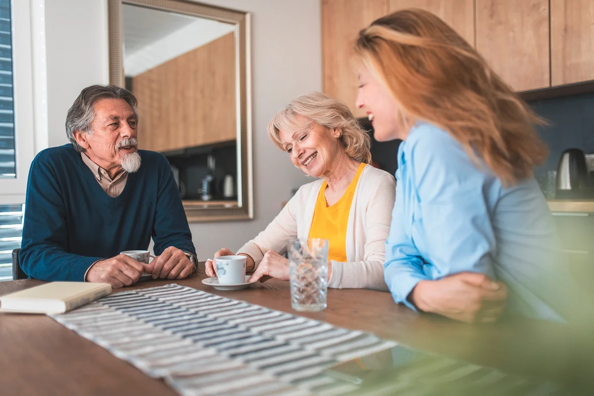 Family talking at dining table in kitchen