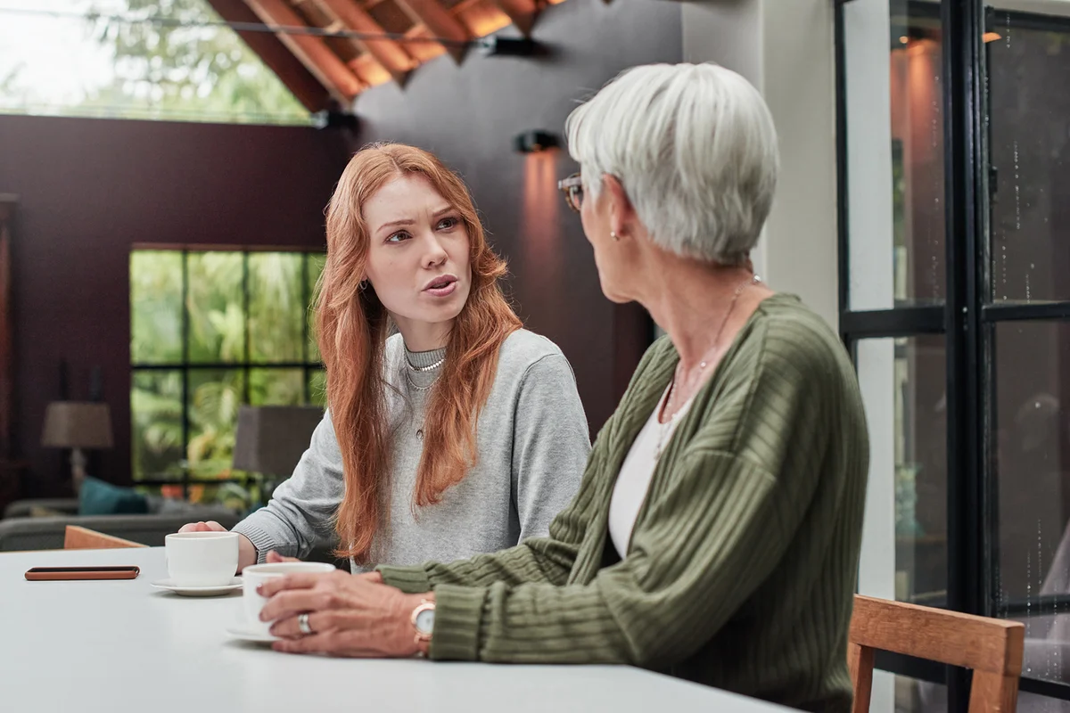 Shot of a young woman having coffee with her elderly mother at home