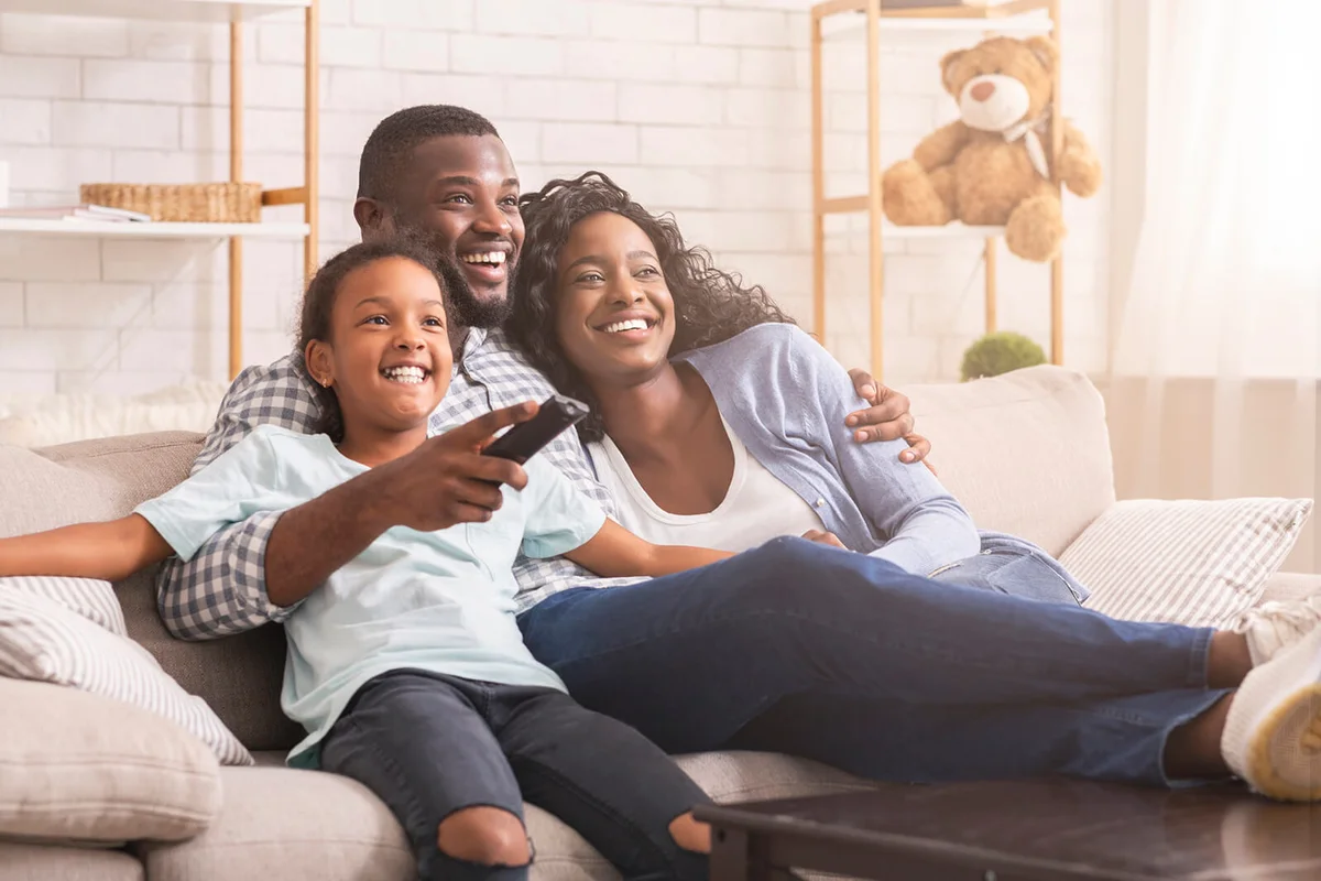 Happy family relaxing and watching tv at home