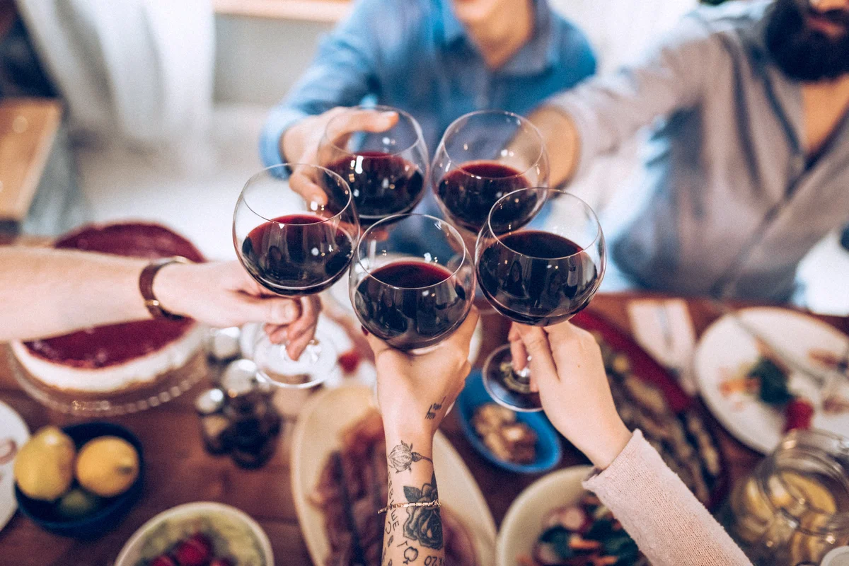 Five people drinking wine in a gathering