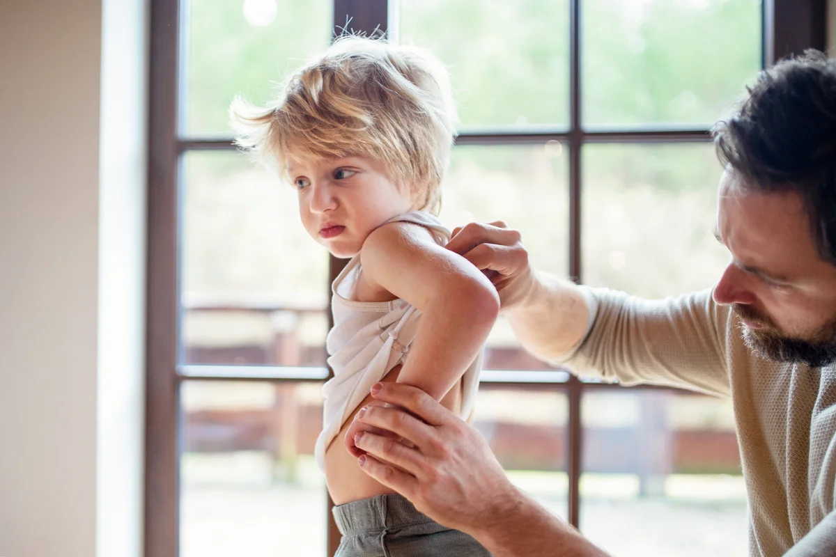 Father checking toddlers back for injuries