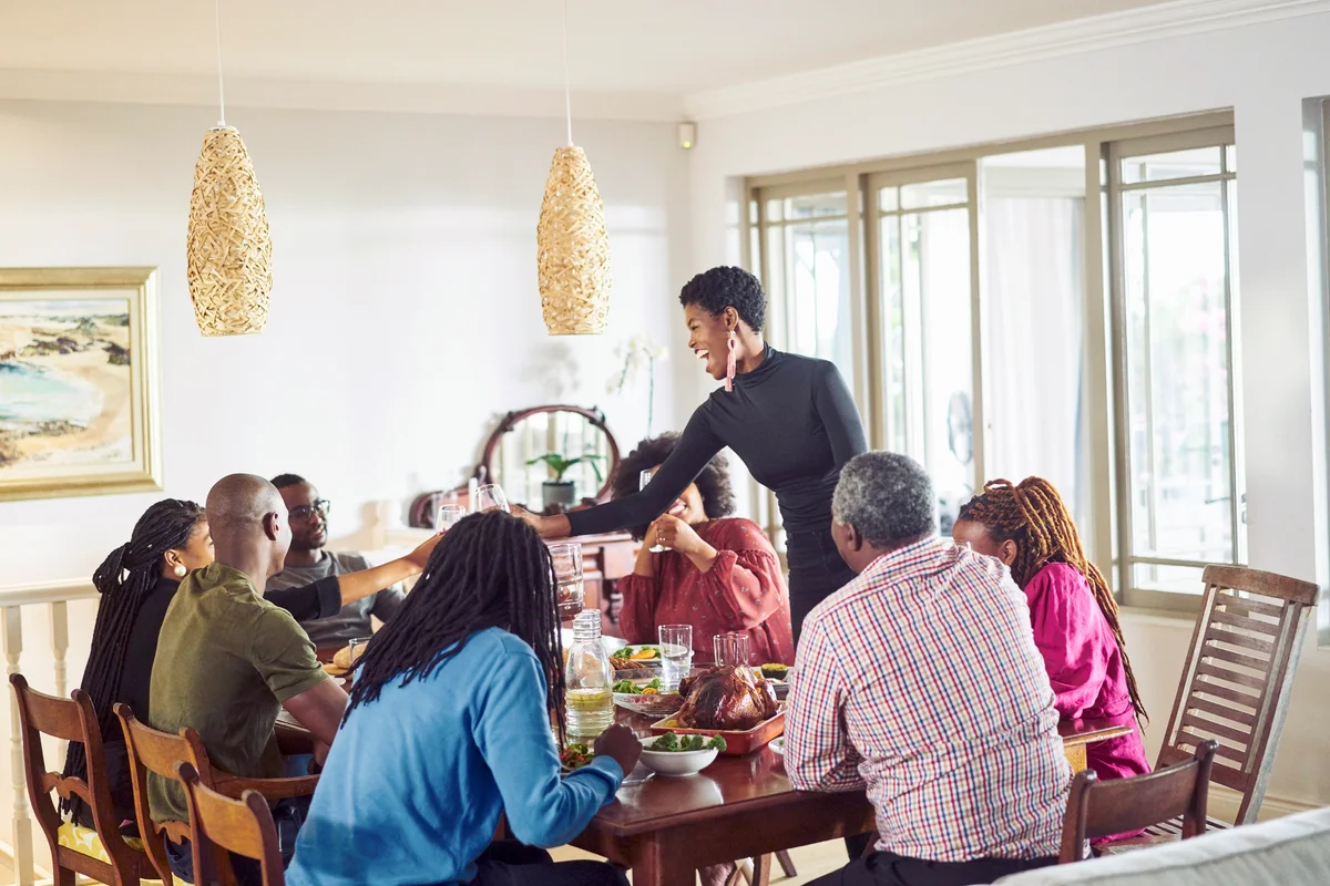 Woman hosting and serving food to in thanksgiving