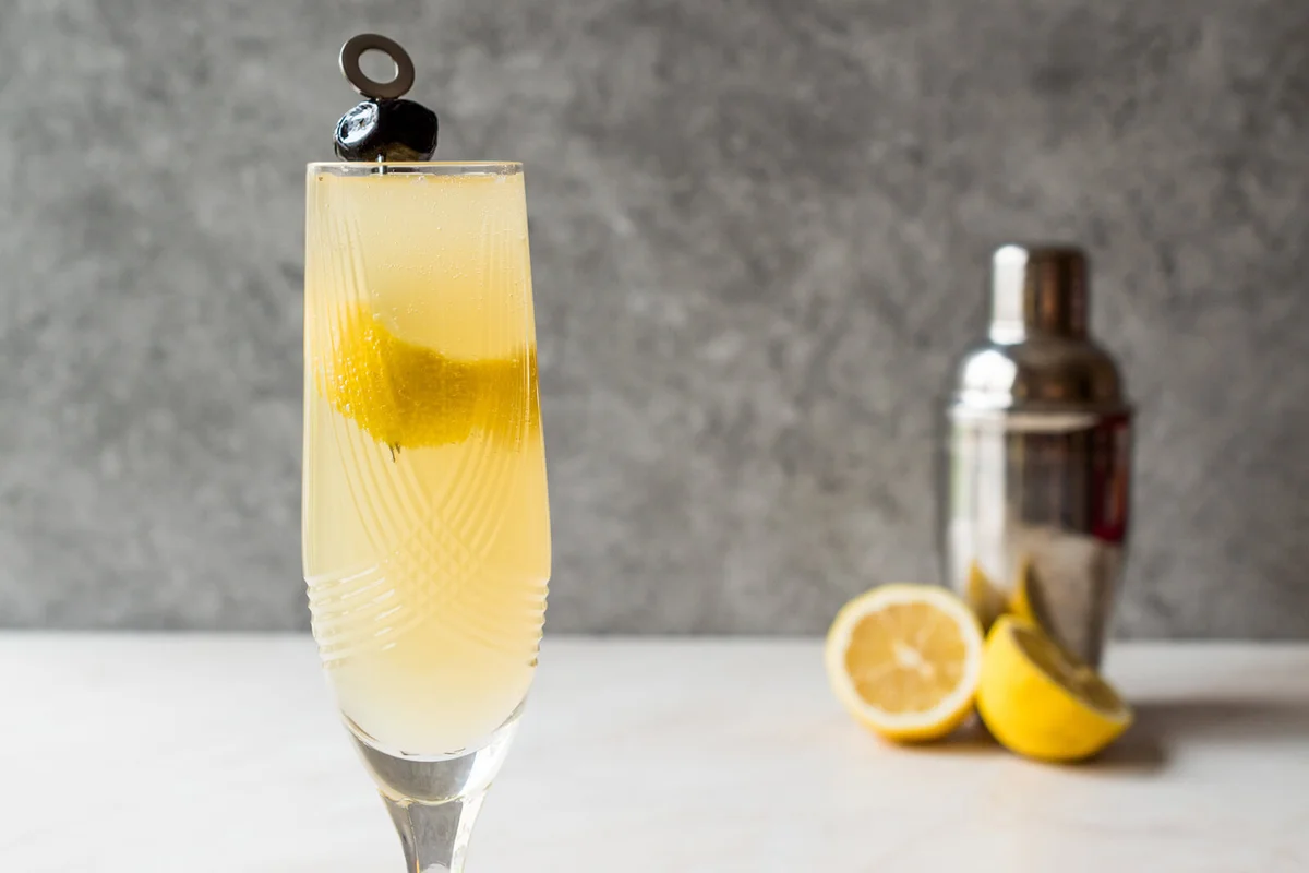 French 75 Champagne Cocktail with Lemon Peel and Black Olive