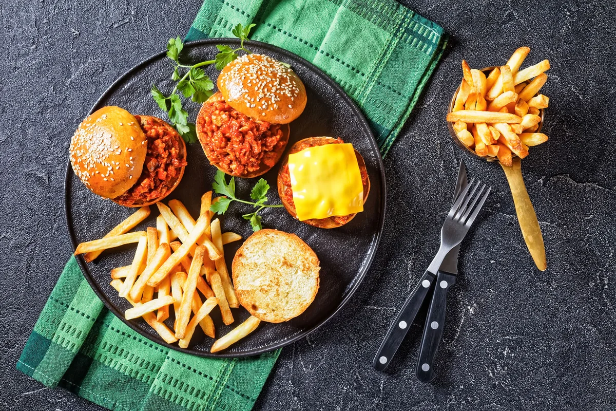 Homemade BBQ Sloppy Joe sandwiches with french Fries on a black plate