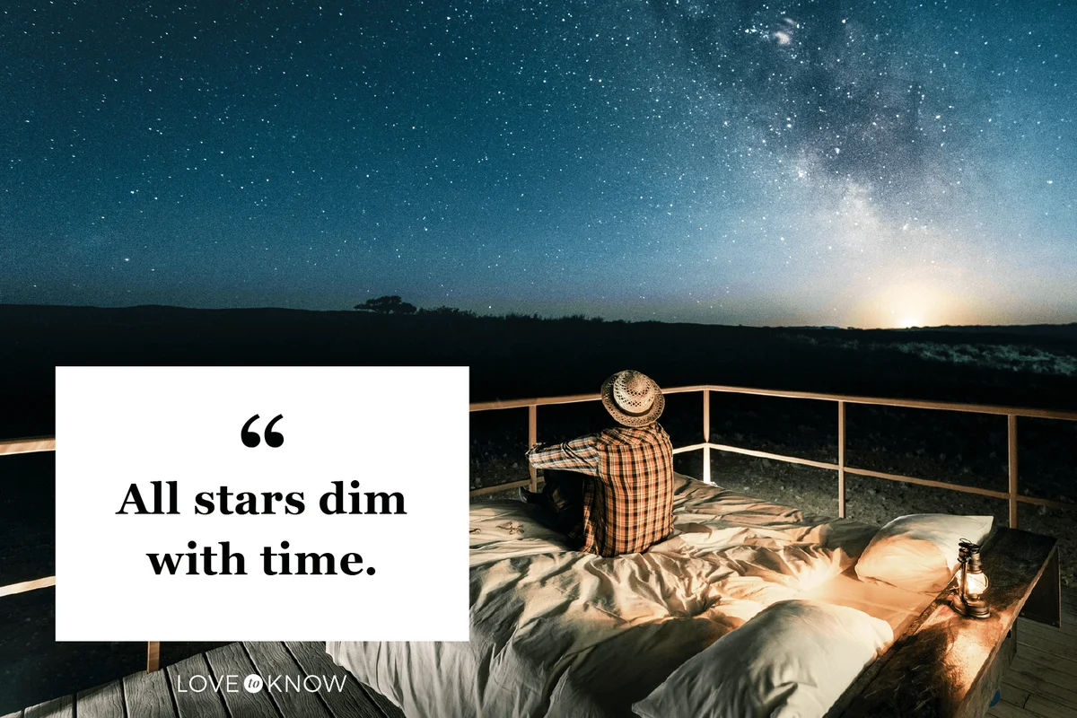 Tourist sitting in bed outdoors under a starry sky