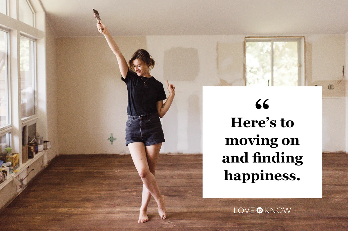 Woman holding paintbrush and dancing in new home